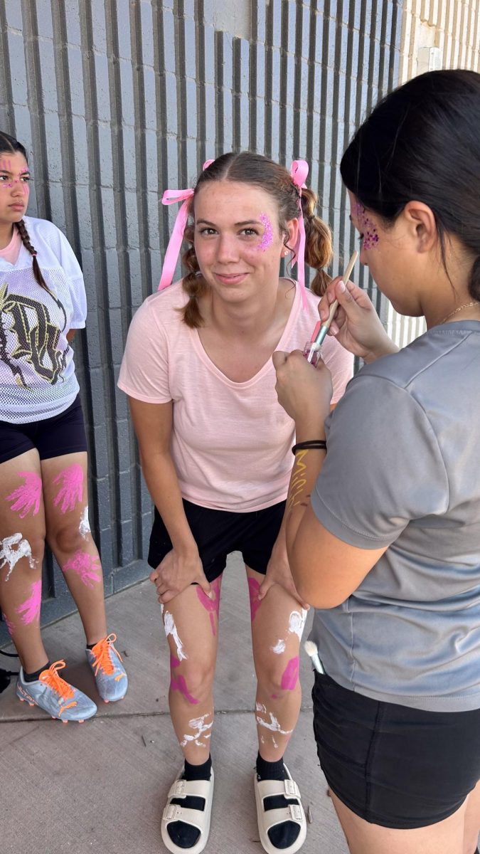 Silver squad quarterback Brooklynn Garzon gets her face painted before Fridays powder puff matchup against the Gold team.