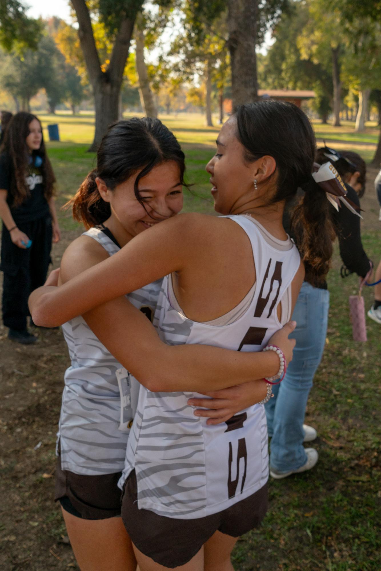 Senior cross country runners Miley Hernandez Moreno (left) and Alexa Cruz Rivera celebrate after Thursday's SYHL championships.