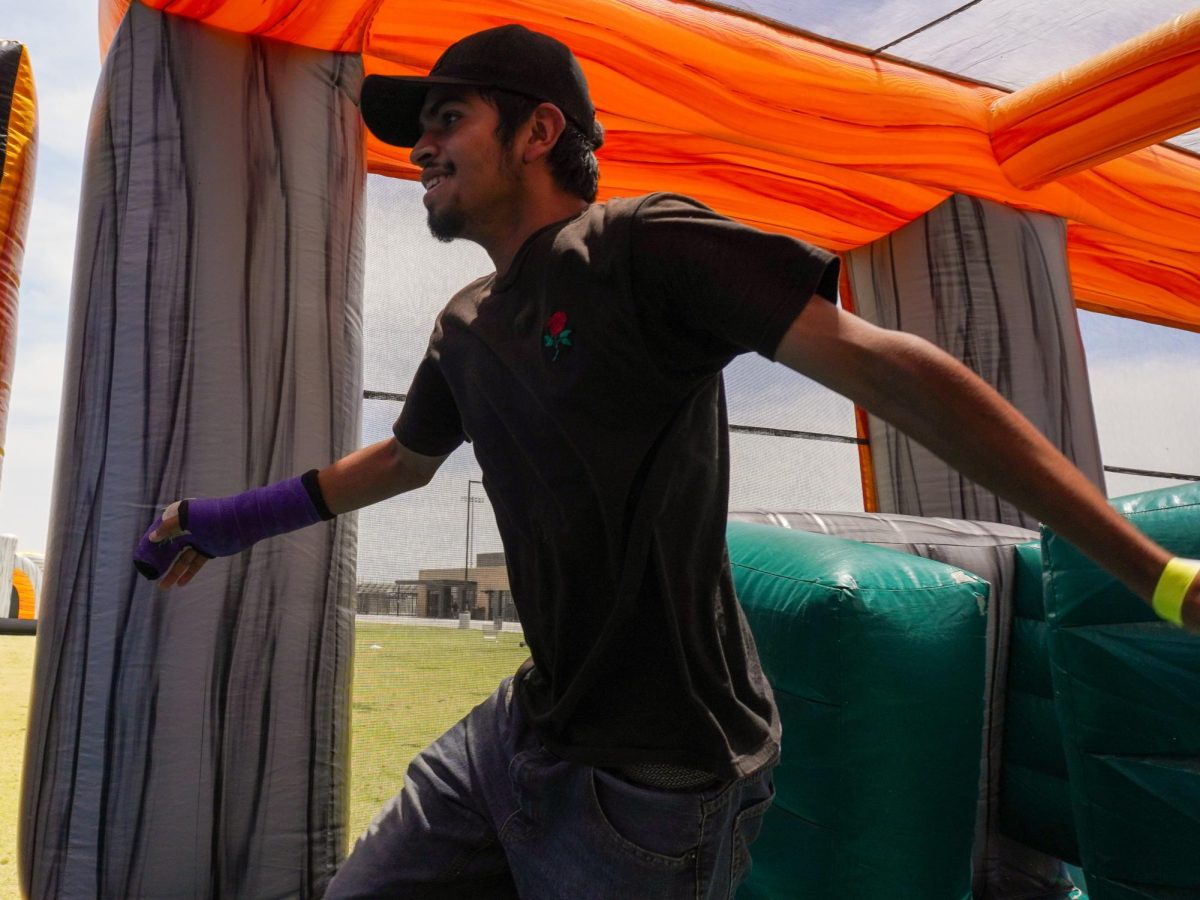 Senior Miguel Lopez navigates his way through one of the inflatable obstacle courses set up on the football practice fields during Wednesday's Senior Day activities.