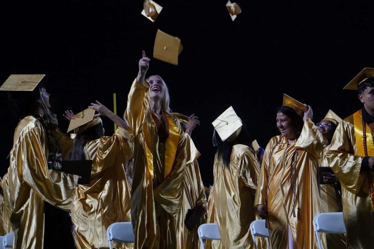 Aly McChristian (third from left) watches as she tosses her cap into the air at the conclusion of Del Oro's first graduation ceremony on May 30.