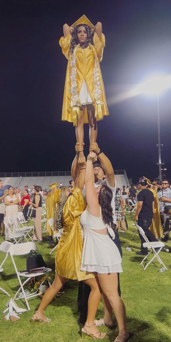 Ta'Hara Stevens (top) is held up by a trio of cheer teammates.
