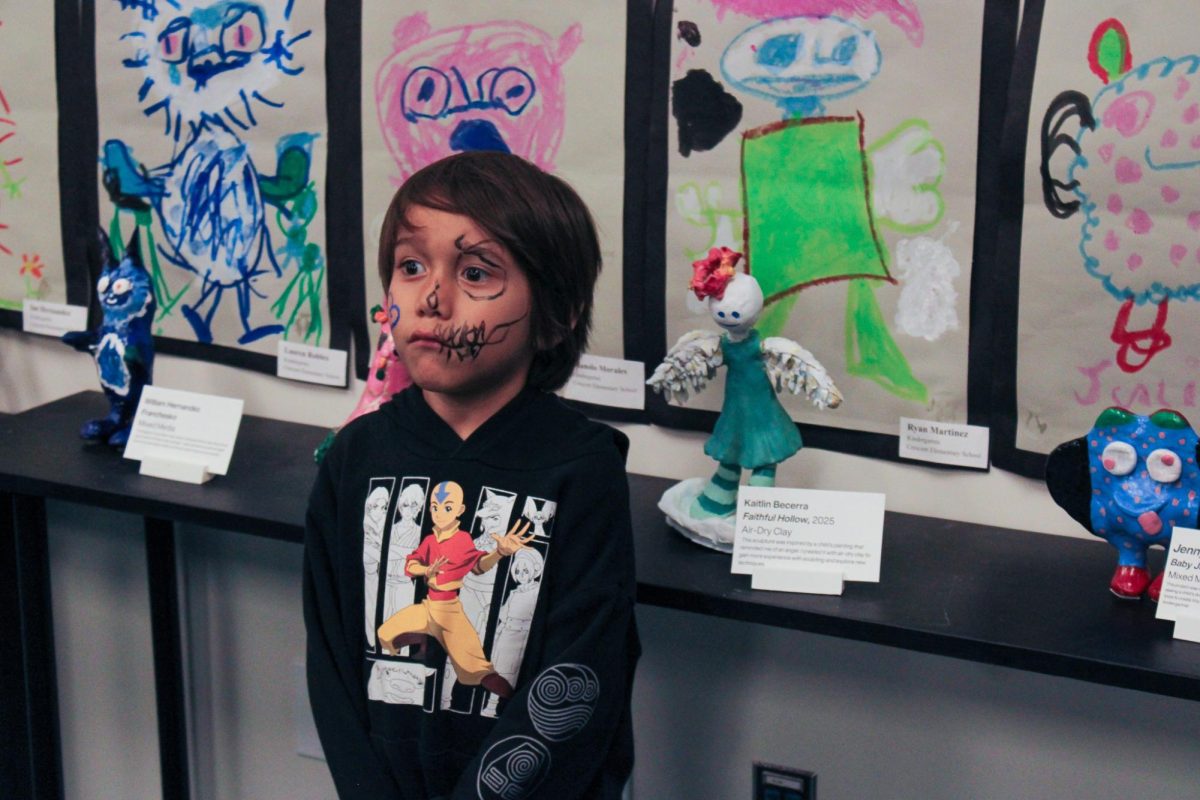 Crescent Elementary pupil Ryan Martinez poses in front of his artwork and a clay remake based on his drawing made by Del Oro senior Kaitlin Beccerra.